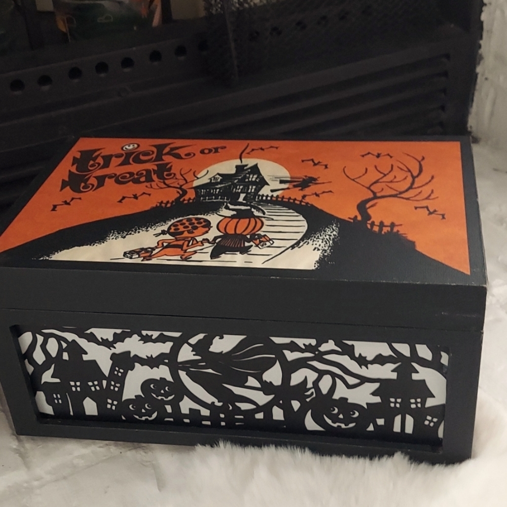 Halloween storage box with small velvet pumpkins inside.
